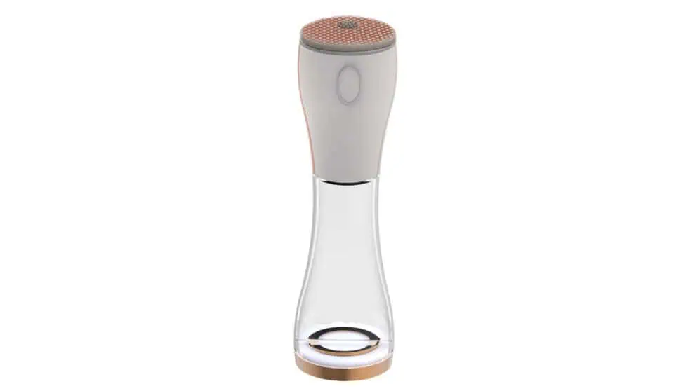 A modern, sleek beauty device with a white and gold design, featuring a textured, circular top and a transparent lower section, standing upright on a flat surface.