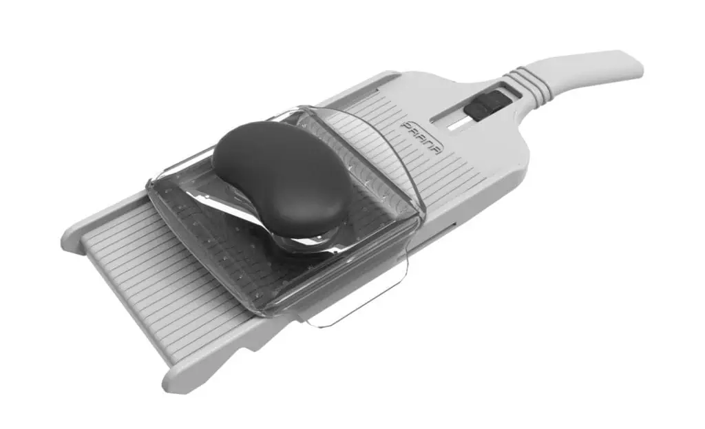 A white and gray vegetable slicer with a black hand guard and adjustable thickness settings, designed for safely and evenly slicing fruits and vegetables.