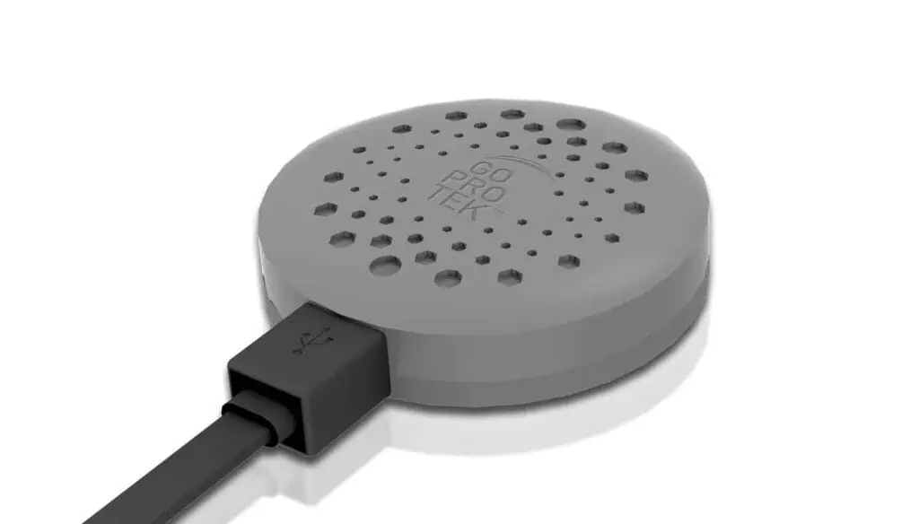 A round, gray electronic device labeled GO PROTEK with multiple holes on top, connected to a USB cable on a white background.
