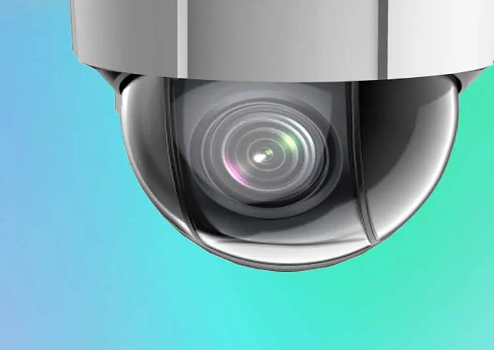 Close-up of a security camera dome with a visible lens, set against a blue and green gradient background.