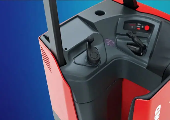 Close-up view of the control panel and operator compartment of a red industrial vehicle, likely a forklift or warehouse truck, against a blue gradient background.